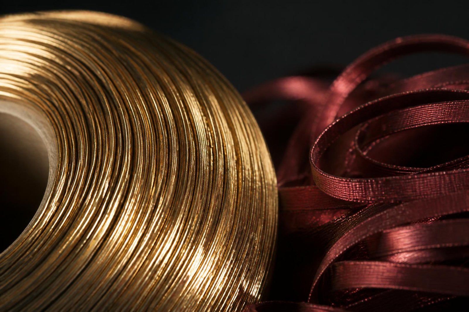 Macro view of golden jari badla thread and burgundy textile film
